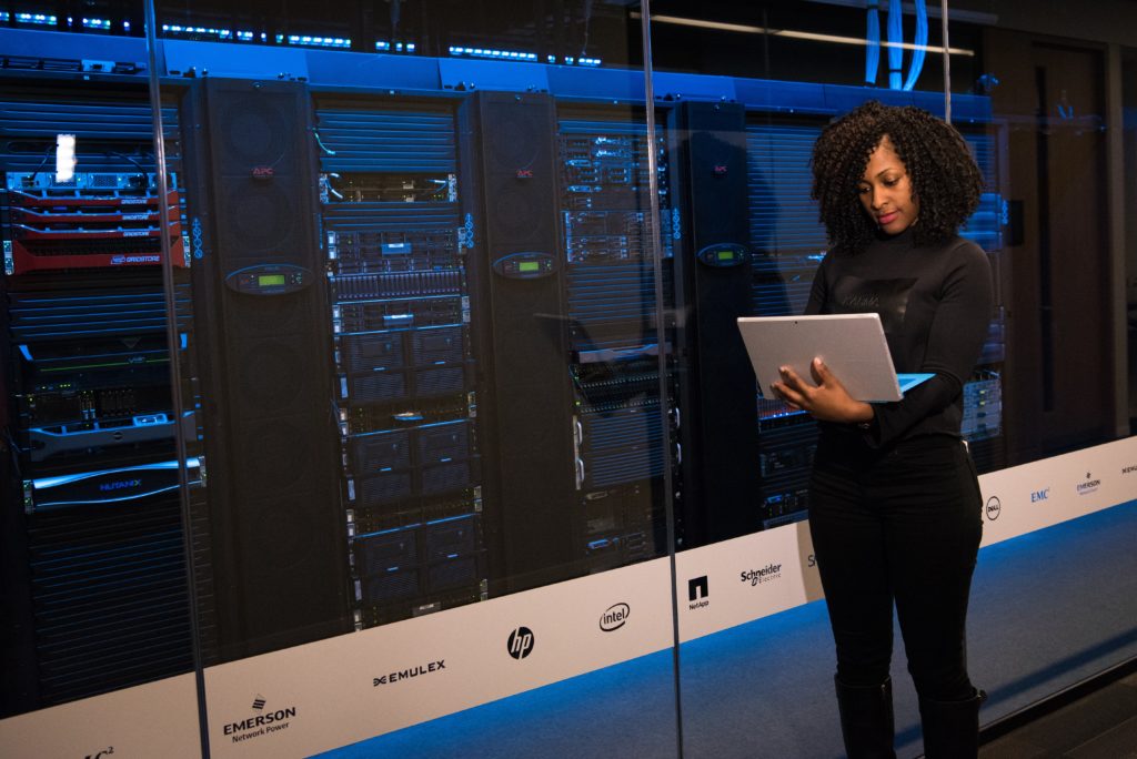 A data center with servers in the background and a woman testing backups in the foreground.